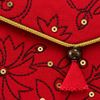 Close-up of embroidered floral detail and gold trim on red Khadi