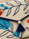 Close-up of hand embroidered navy twigs, pearl and tassel on Khadi envelope